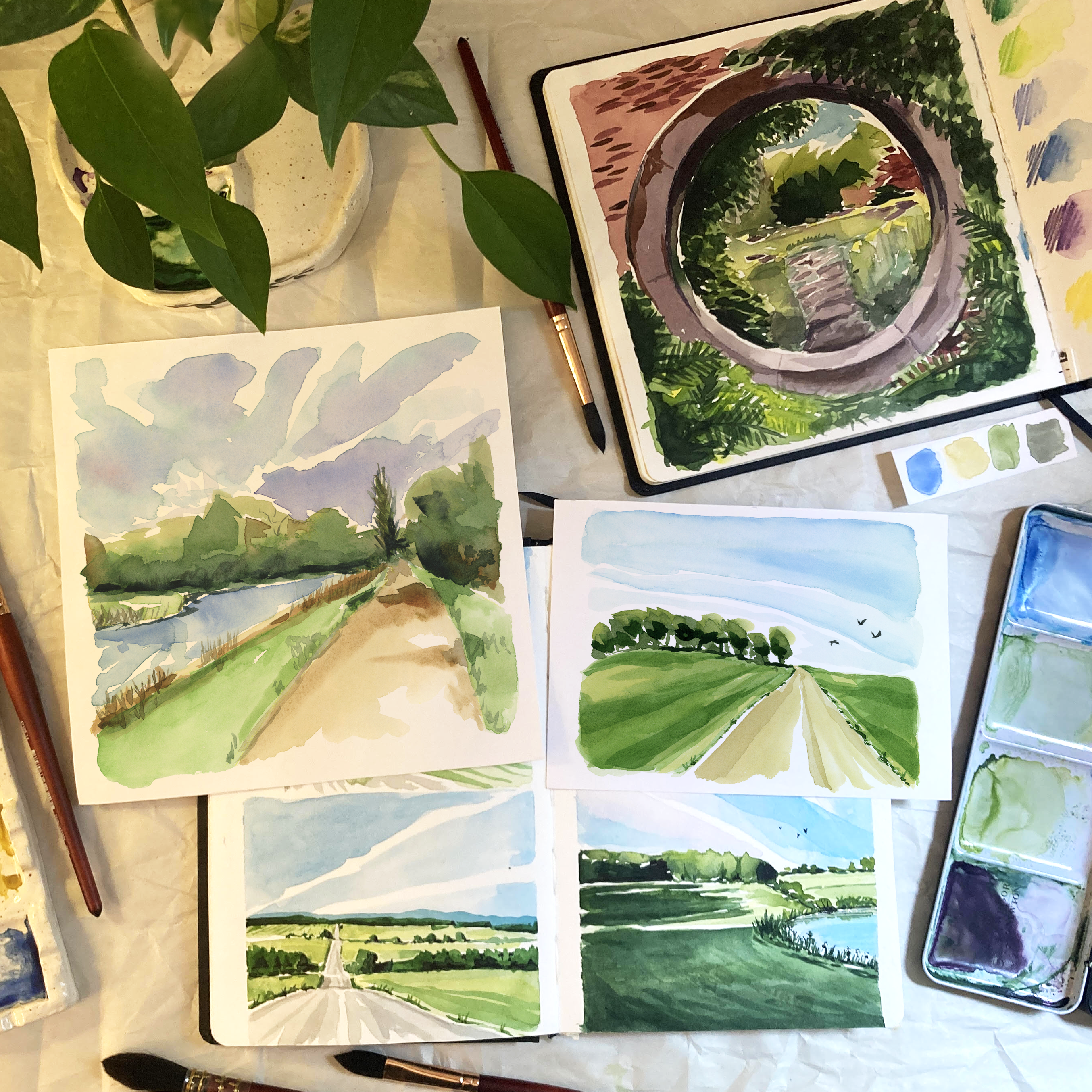 Flat lay of meaningful watercolor landscape paintings made by New England artist Sarah Yancey